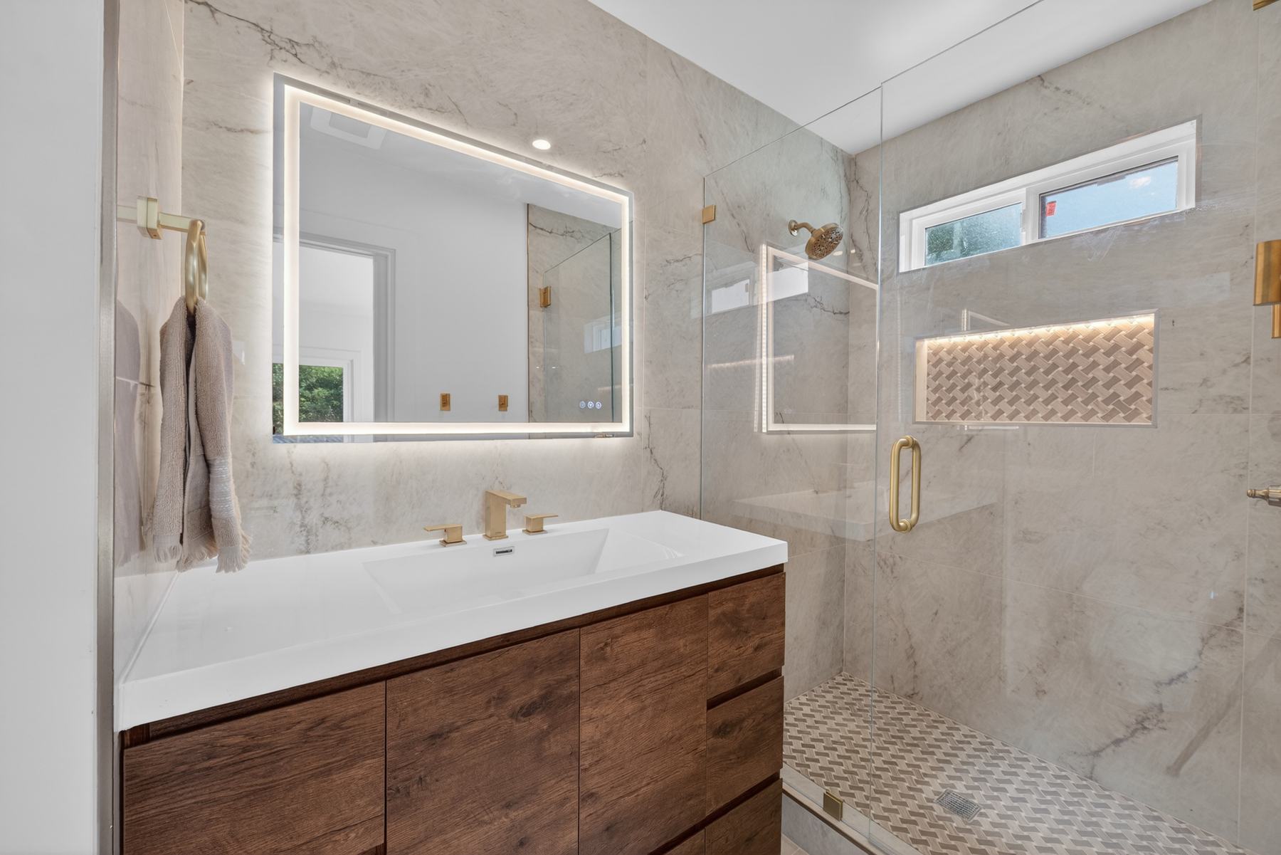 Guest bathroom with marble-look tile and brass fixtures